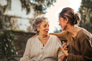 A young woman embraces her grandmother.