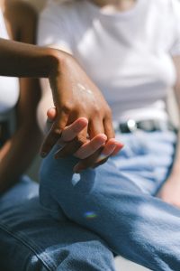 A Black woman holds hands with her white girlfriend.