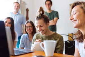 A group of co-workers smiling while on a conference call.