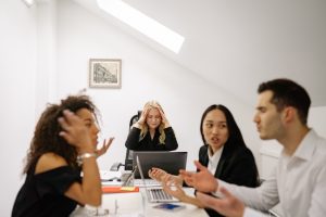 A group of co-workers have an argument around a table.