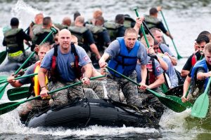 A team of men paddling a raft boat.