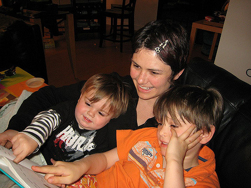 A mother reading to her two young boys