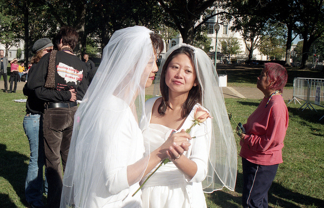 A newlywed lesbian couple both in wedding dresses