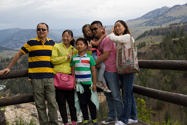 An Asian American family posing by a cliff on a family vacation