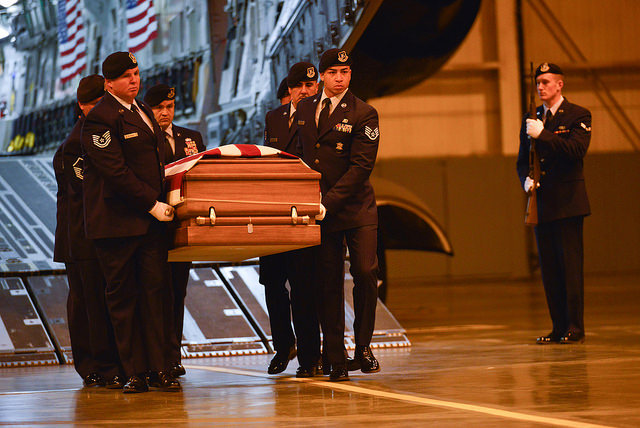 Members of the national guard carrying a casket of one of their fellow fallen, perhaps by suicide due to what was seen in the Iraq or Afghanistan War