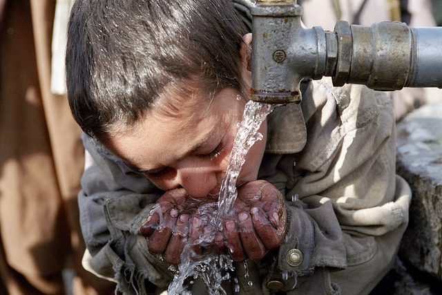 A young resident of Maslakh Camp takes a drink of water.