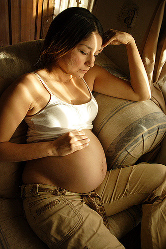 A pregnant woman sitting on a couch