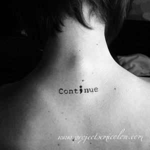 A photo of a tattoo on the back of a woman's neck shows a semicolon in place of the letter i in the word Continue.